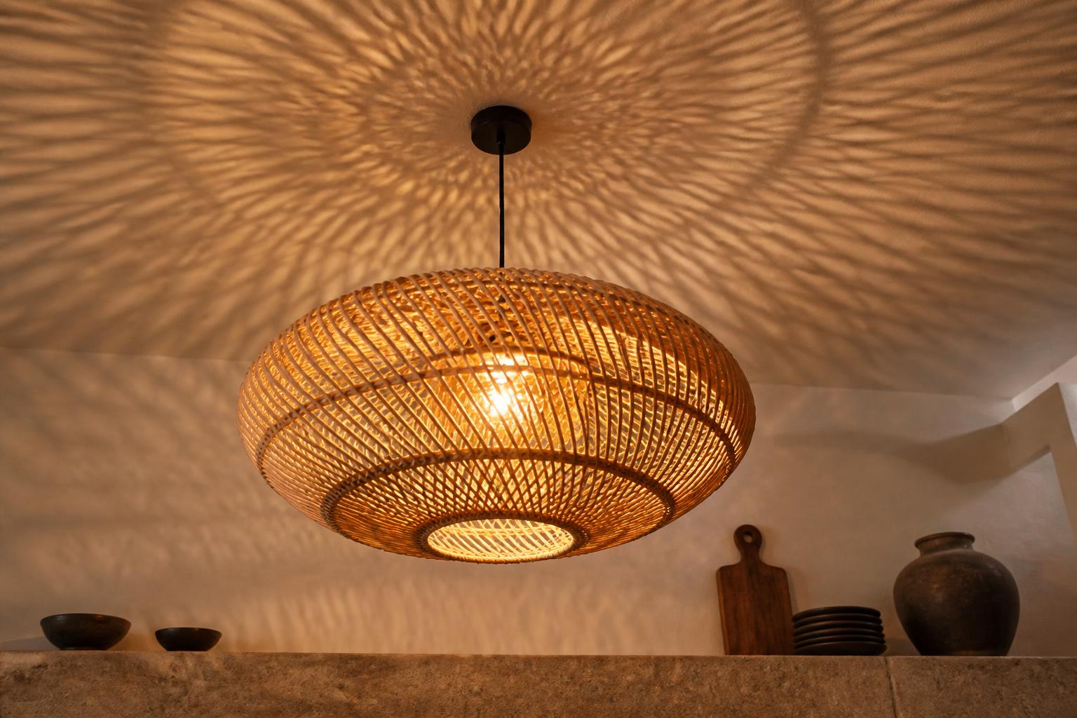 Suspension rotin tressé allumée ombres organiques plafond ambiance wabi-sabi